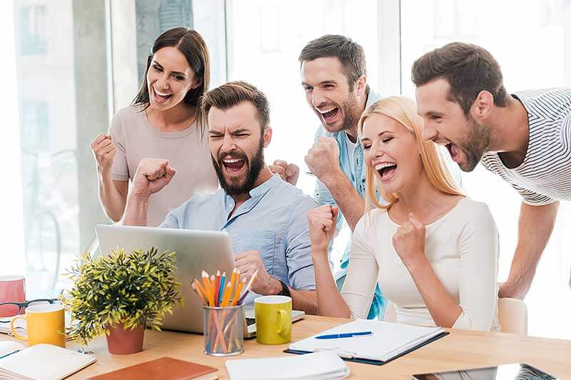 Equipo de Social Media Advertising celebran frente a una computadora