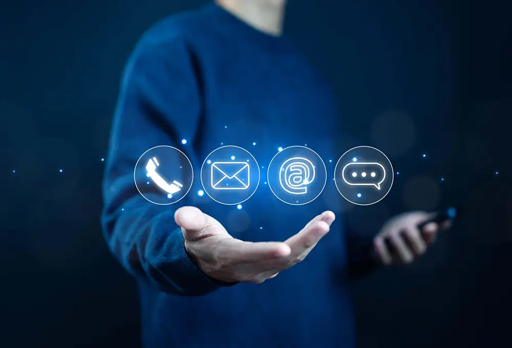 Person holding digital communication icons for phone, email, website, and messaging, symbolizing SEO agency contact methods.
