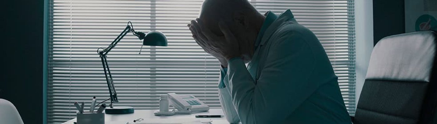 A stressed executive at a desk represents the challenge Link Socially solves with a measurable AI search optimization framework.